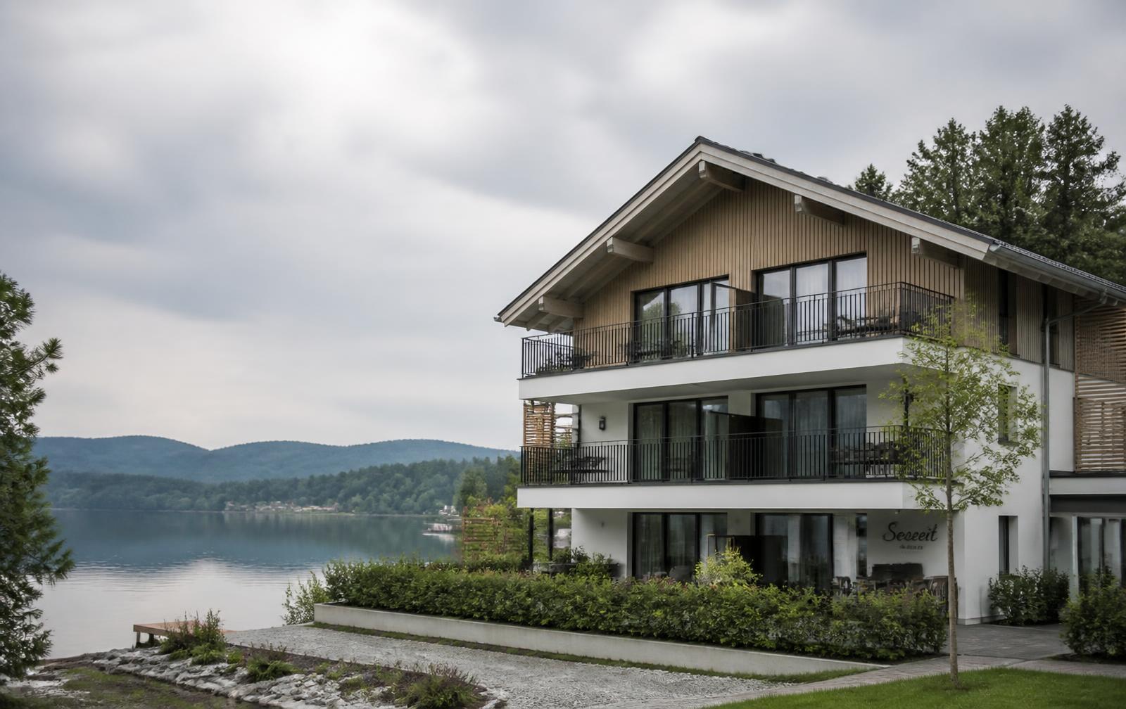 Modernes Ferienhaus mit Holzfassade und Balkonen am See