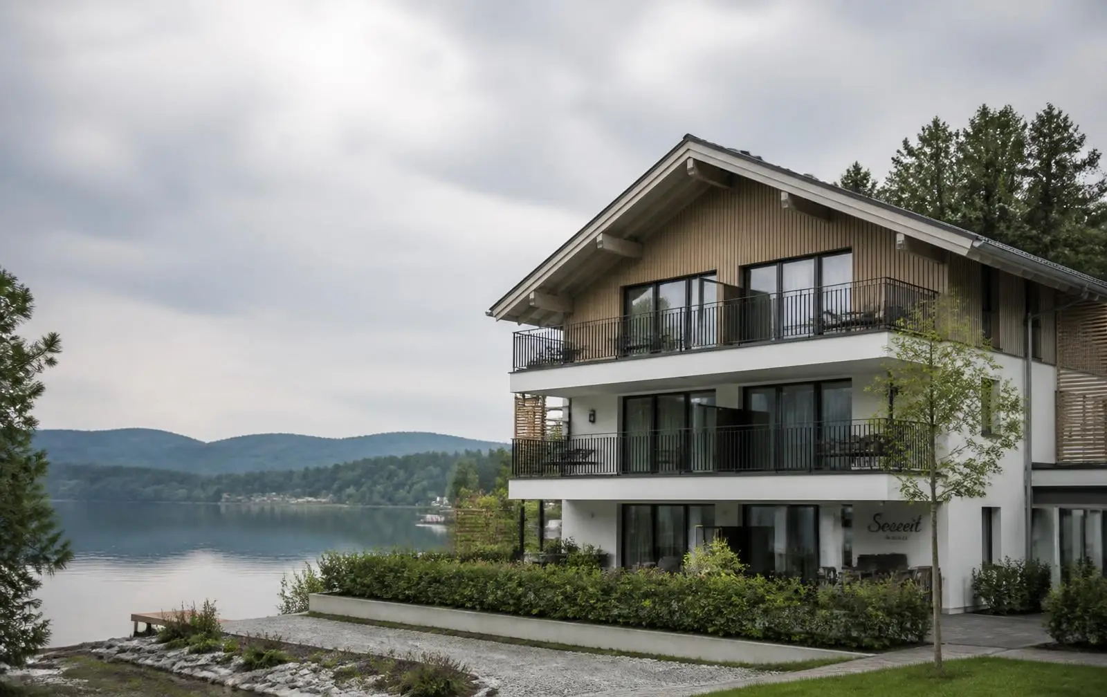 Modernes Ferienhaus mit Holzfassade und Balkonen am See