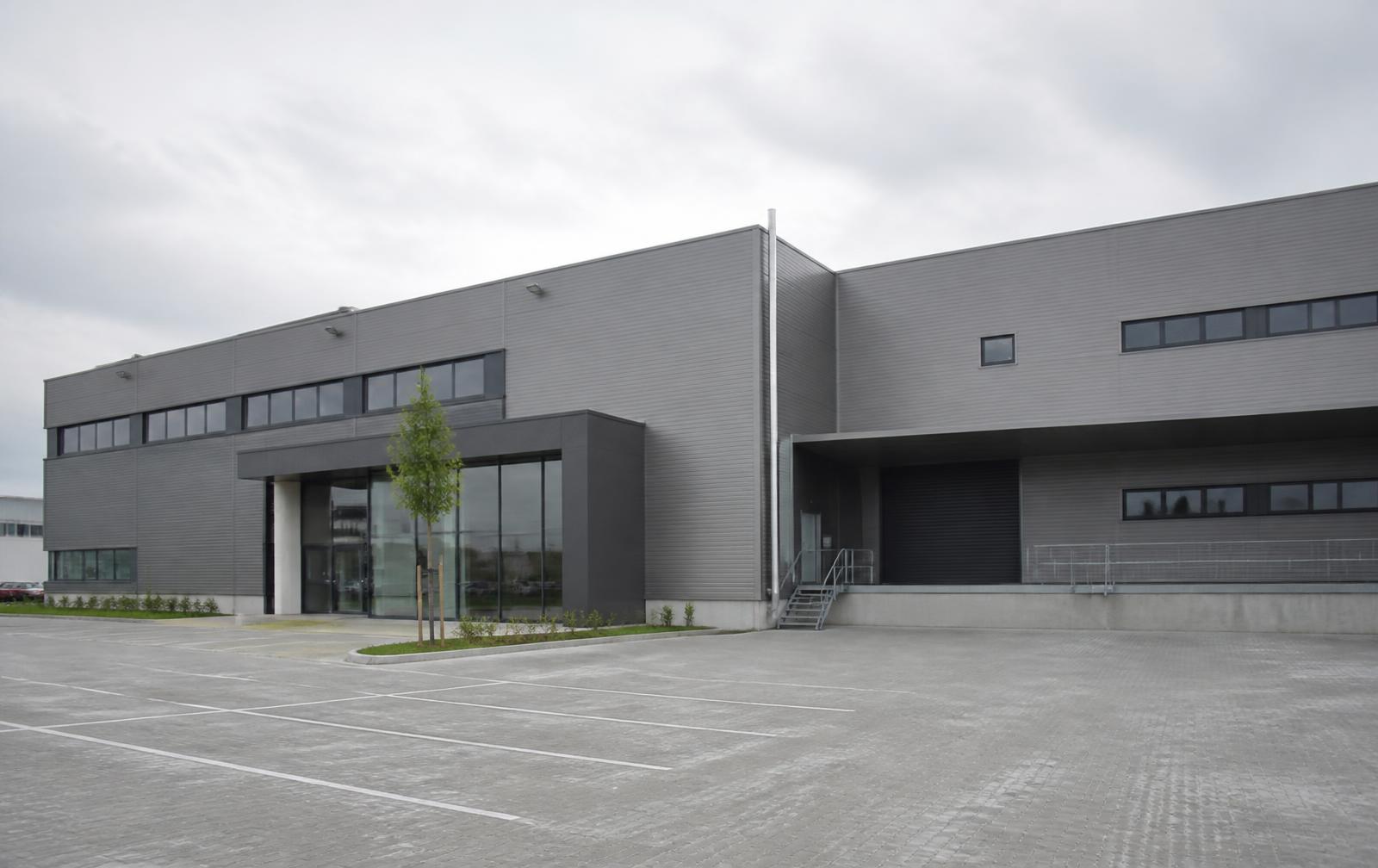 Modernes Gewerbegebäude mit grauer Metallfassade und Anlieferbereich